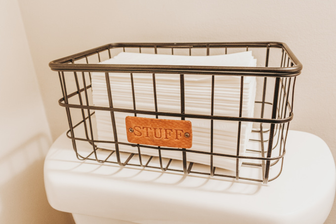 Half bathroom makeover shelving vintage industrial farmhouse decor plants modern tissues in black wire frame basket
