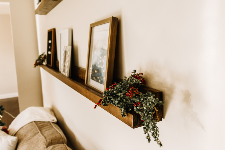 DIY picture frame ledge shelf decorated on wall above couch