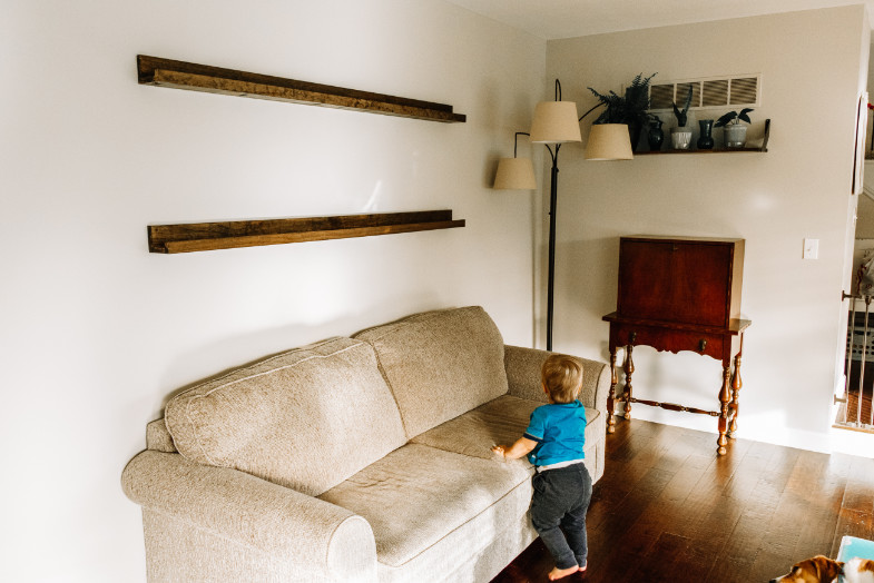 DIY picture frame ledge shelf hung on wall with toddler