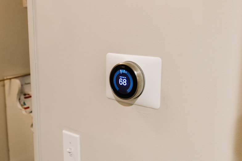 Google Nest Learning Thermostat installed on wall in entryway displaying 68 degrees Fahrenheit